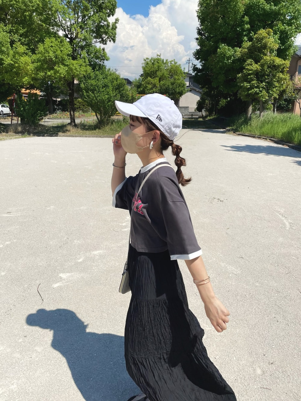 グレー系のTシャツ/カットソー、ブラック系のスカート、ホワイト系のキャップを着用したレディースの夏コーディネートの5枚目の写真