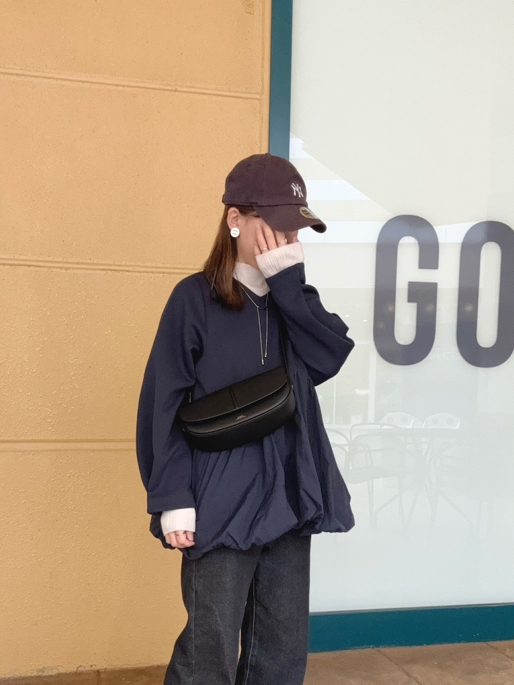 ブルー系のTシャツ/カットソー、ブラック系のデニムパンツ、ブラック系のショルダーバッグを着用したレディースの秋コーディネートの4枚目の写真