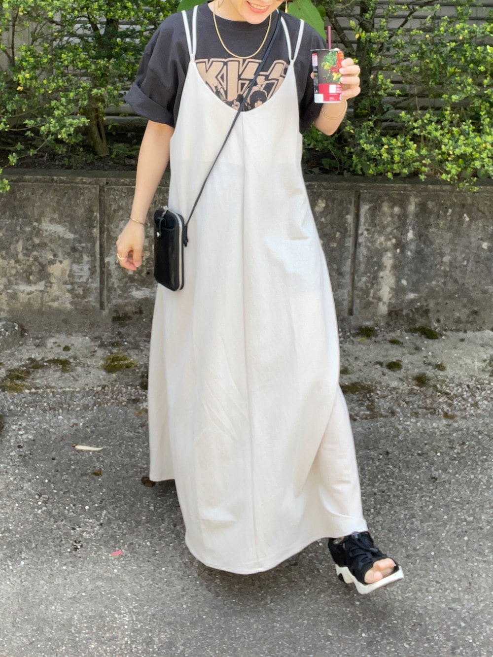 ベージュ系のワンピース、ブラック系のTシャツ/カットソー、ブラック系のショルダーバッグを着用したレディースの春コーディネートの5枚目の写真