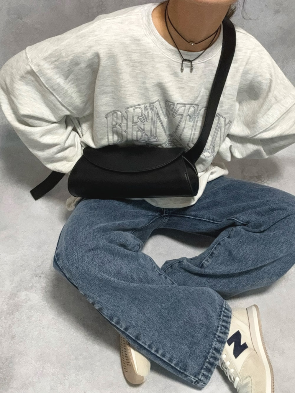 グレー系のスウェット、ブラック系のショルダーバッグ、ブラック系のスカートを着用したレディースの秋コーディネートの4枚目の写真