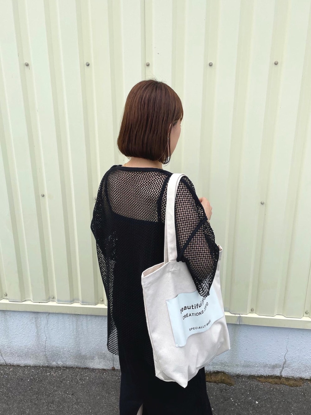 ブラック系のTシャツ/カットソー、ブラック系のワンピース、ホワイト系のトートバッグを着用したレディースの秋コーディネートの2枚目の写真