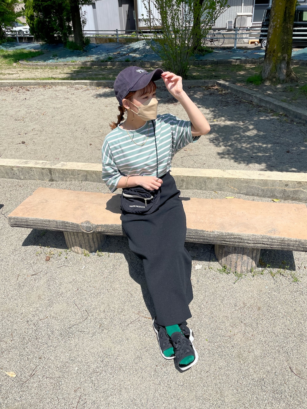 グリーン系のTシャツ/カットソー、ブラック系のスカート、ブラック系のショルダーバッグを着用したレディースの夏コーディネートの2枚目の写真