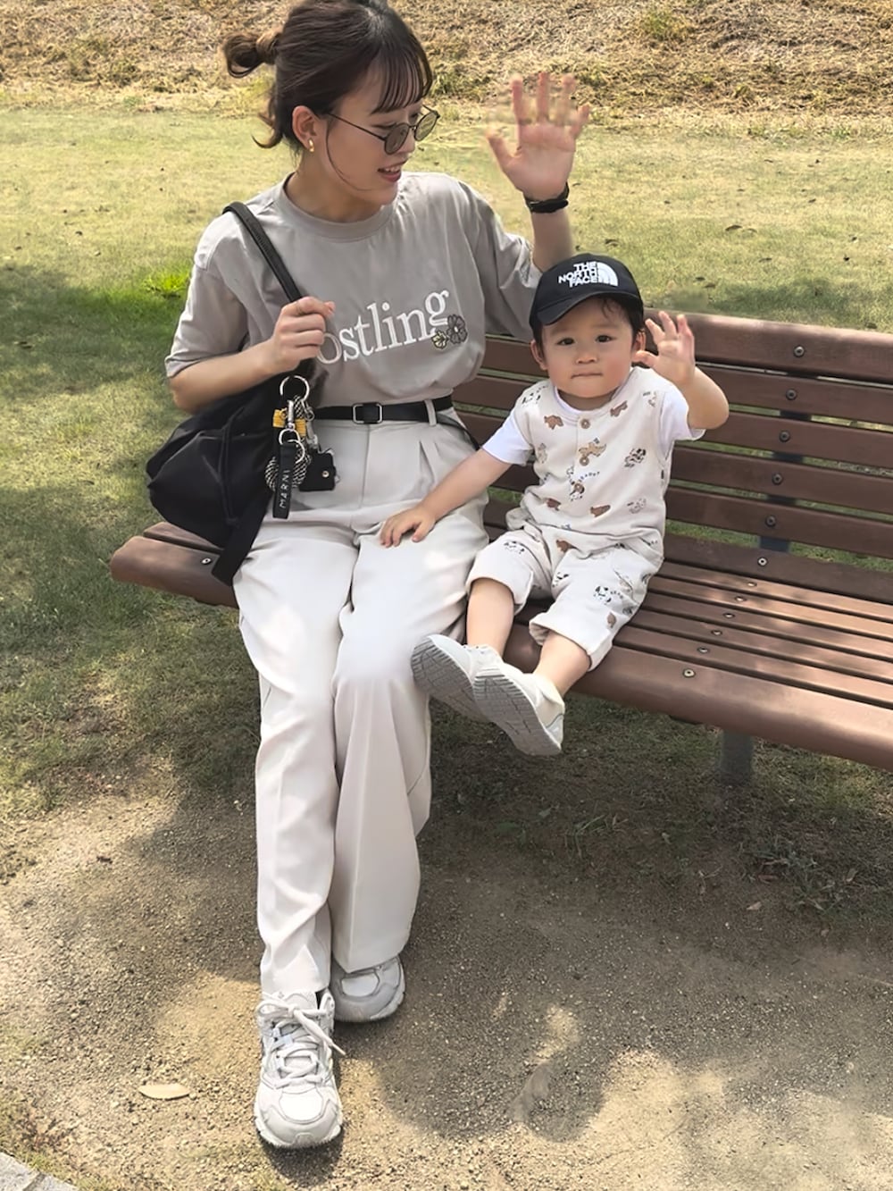 ホワイト系のスラックス、ブラック系のボストンバッグ、ベージュ系のTシャツ/カットソーを着用したレディースの秋コーディネートの2枚目の写真