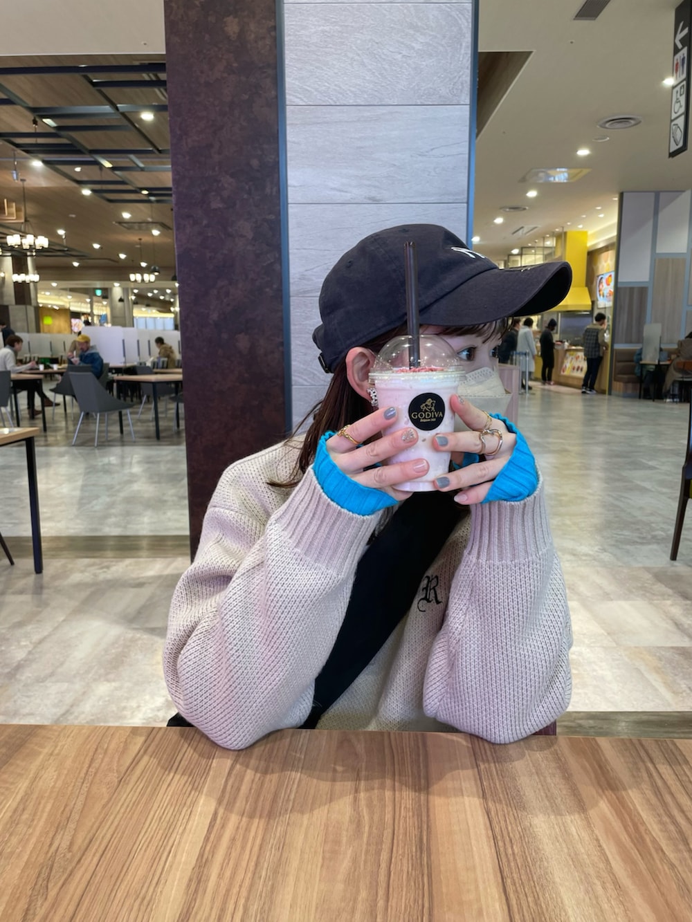 ベージュ系のニット/セーター、ブラック系のスカート、ブラック系のショルダーバッグを着用したレディースの春コーディネートの3枚目の写真