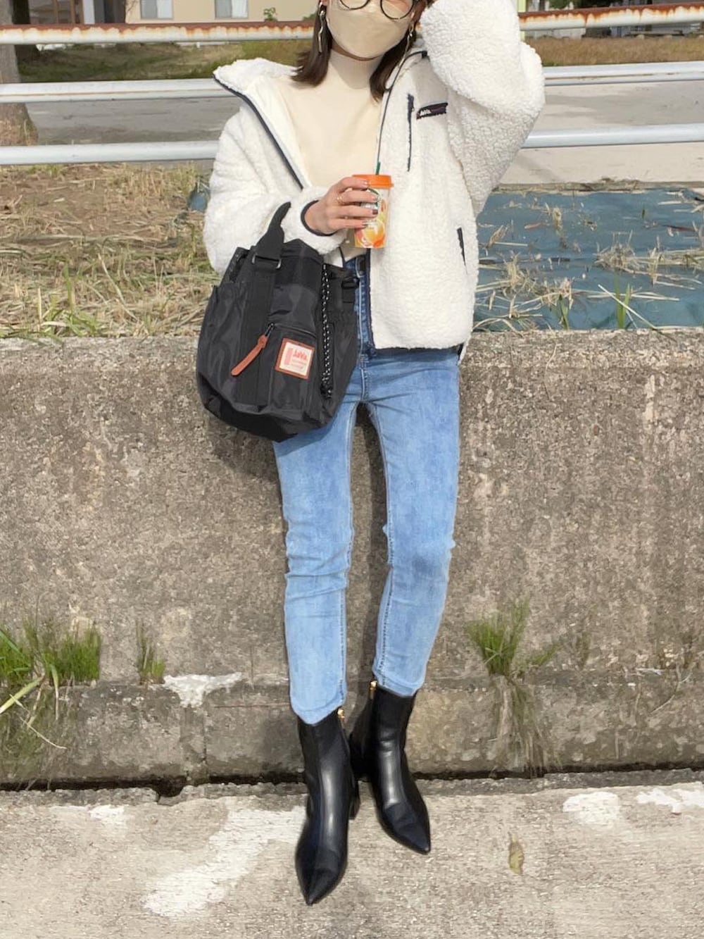 ホワイト系のブルゾン、ホワイト系のニット/セーター、ブラック系のショルダーバッグを着用したレディースの冬コーディネートの4枚目の写真