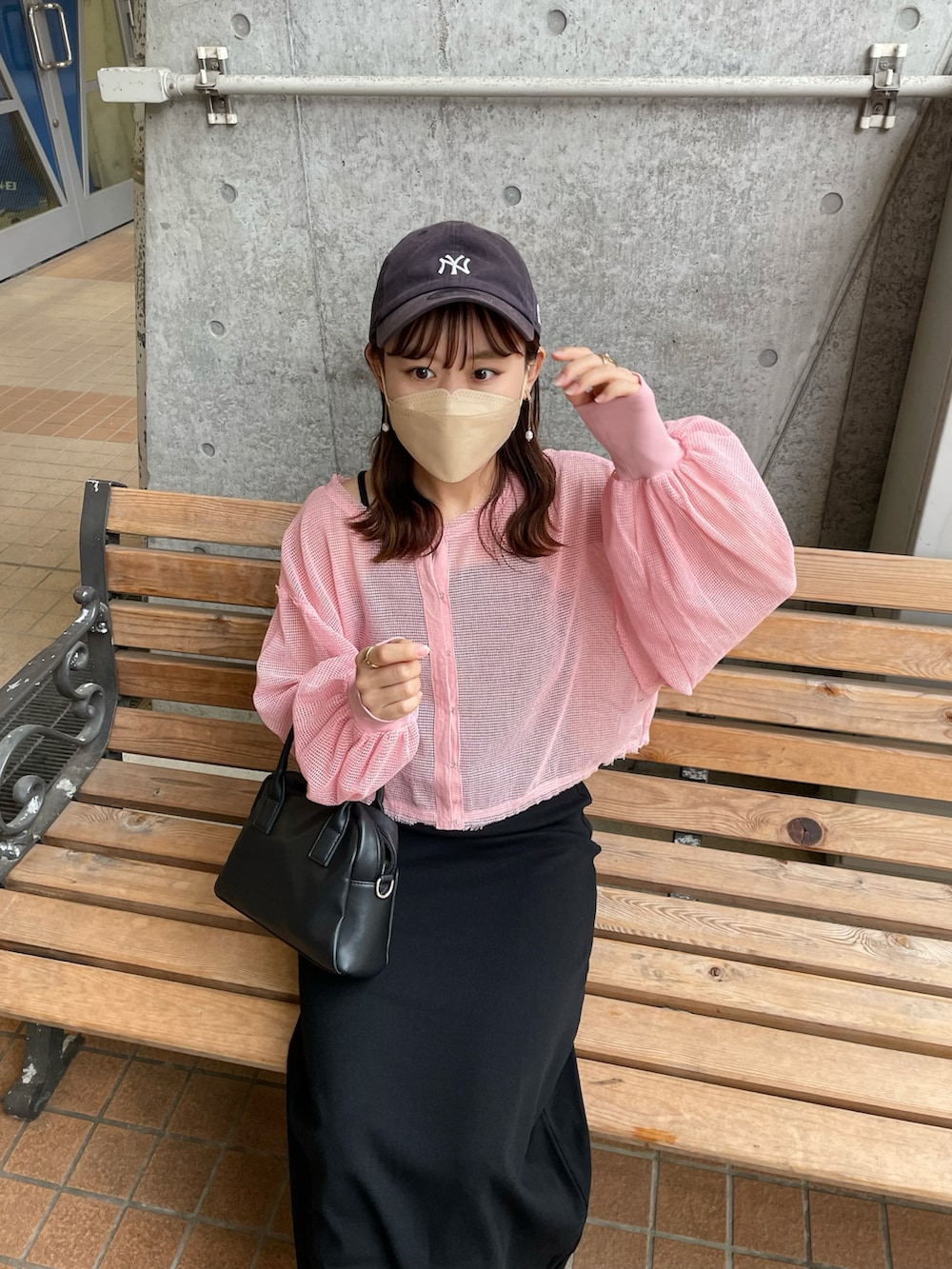 ピンク系のカーディガン/ボレロ、ブラック系のワンピース、ホワイト系のスニーカーを着用したレディースの春コーディネートの2枚目の写真