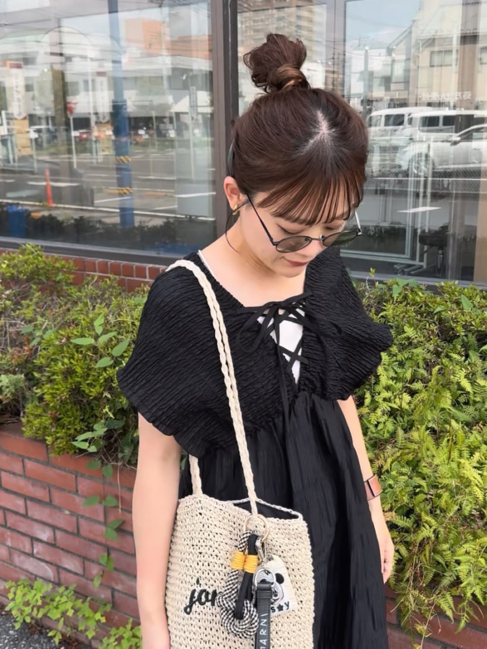 ブラック系のワンピース、ベージュ系のかごバッグ、ブラック系のサンダルを着用したレディースの夏コーディネートの5枚目の写真