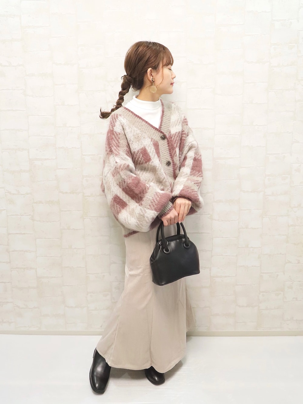 ピンク系のカーディガン/ボレロ、ホワイト系のスカート、ブラック系のブーツを着用したレディースの秋コーディネートの2枚目の写真