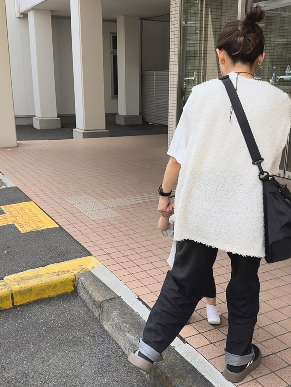 ホワイト系のトップス、ブラック系のパンツ、ブラック系のバッグを着用したレディースの秋コーディネートの4枚目の写真