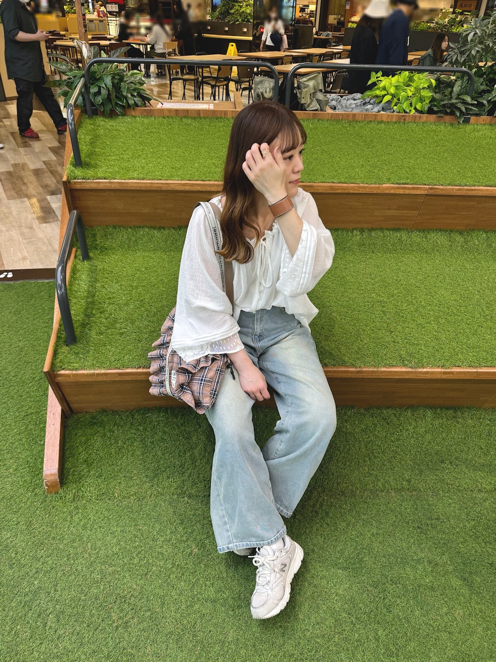 ホワイト系のトップス、ブルー系のデニムパンツ、ピンク系のトートバッグを着用したレディースの春コーディネートの3枚目の写真