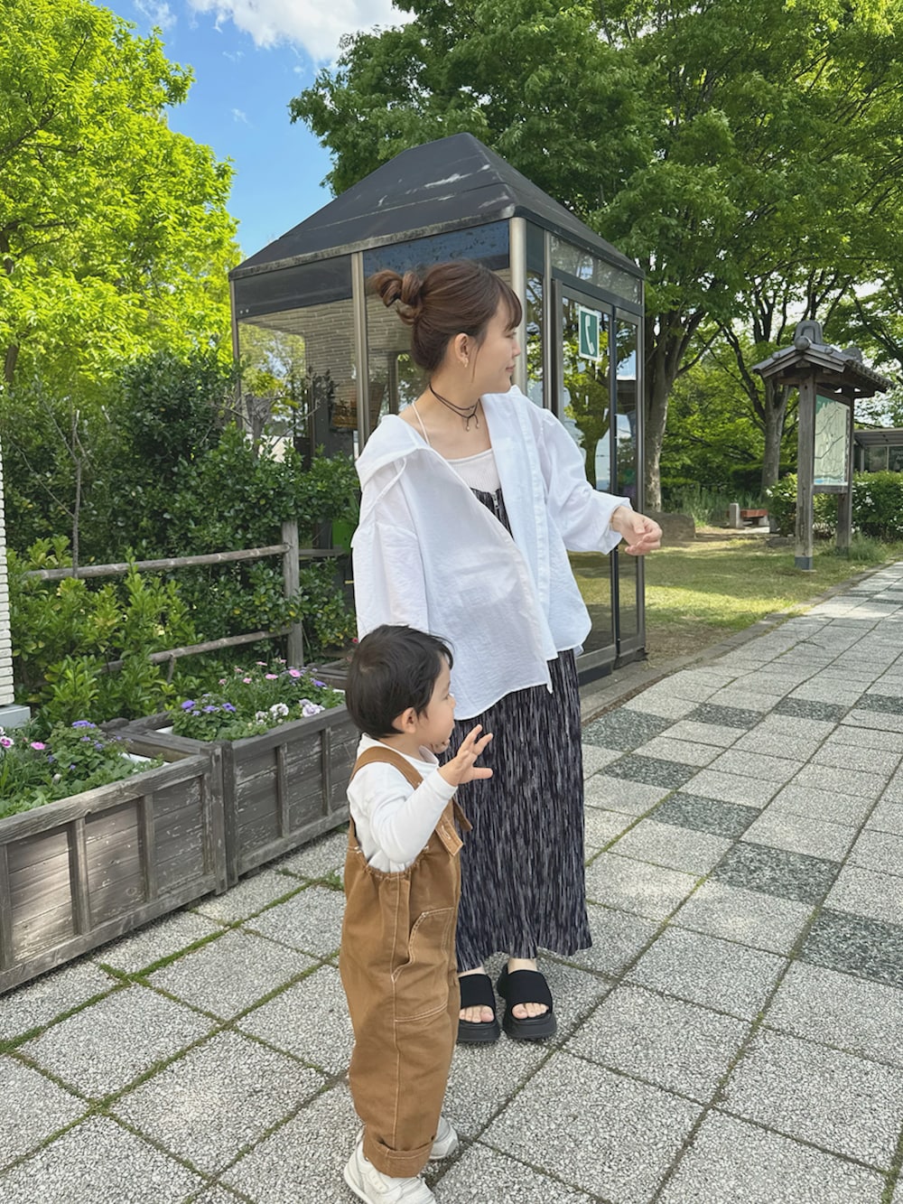 ホワイト系のシャツ/ブラウス、ブラック系のワンピース、ブラック系のサンダルを着用したレディースの夏コーディネートの2枚目の写真