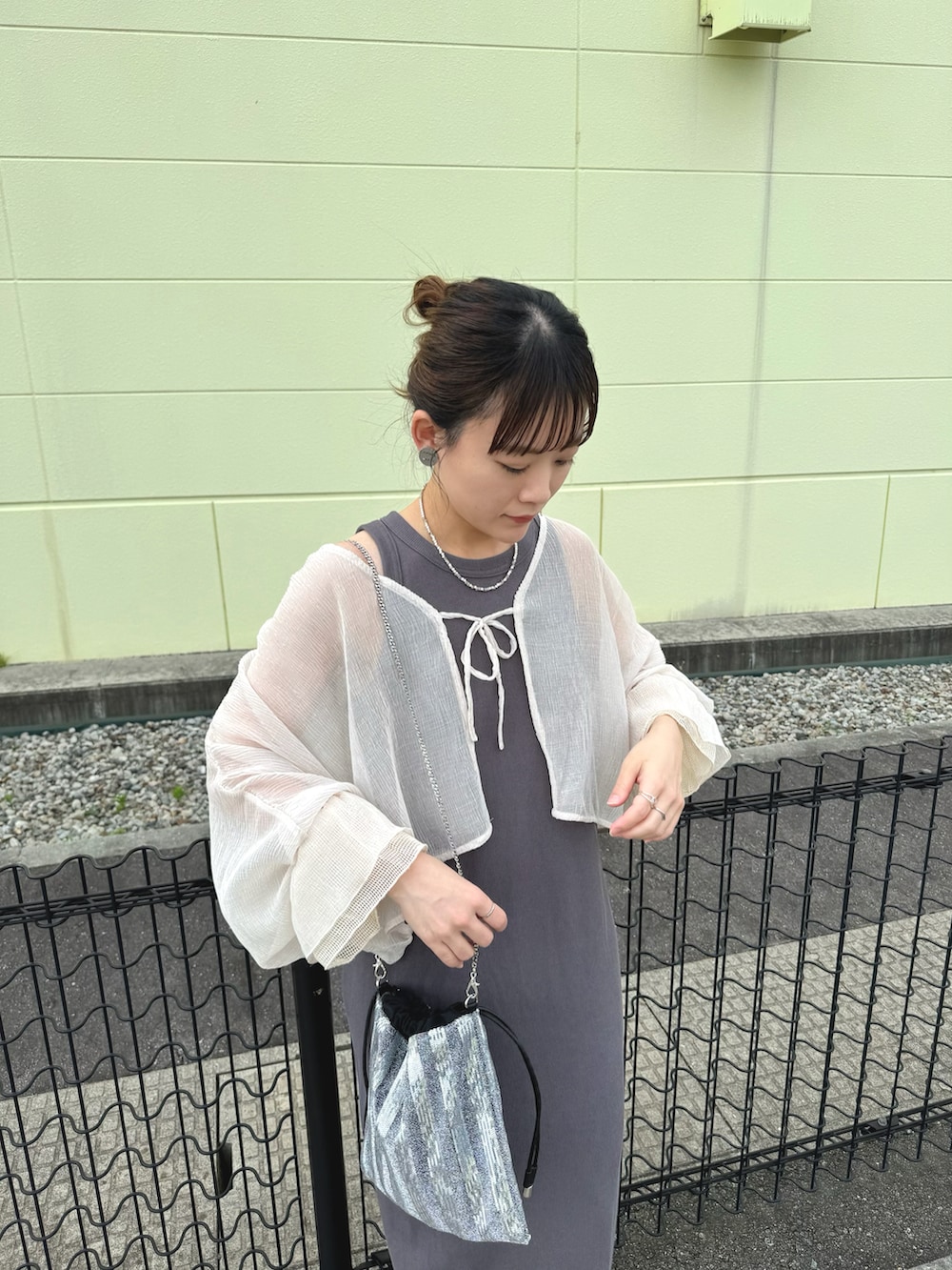 ベージュ系のカーディガン/ボレロ、シルバー系のショルダーバッグ、ブラック系のサンダルを着用したレディースの夏コーディネートの2枚目の写真