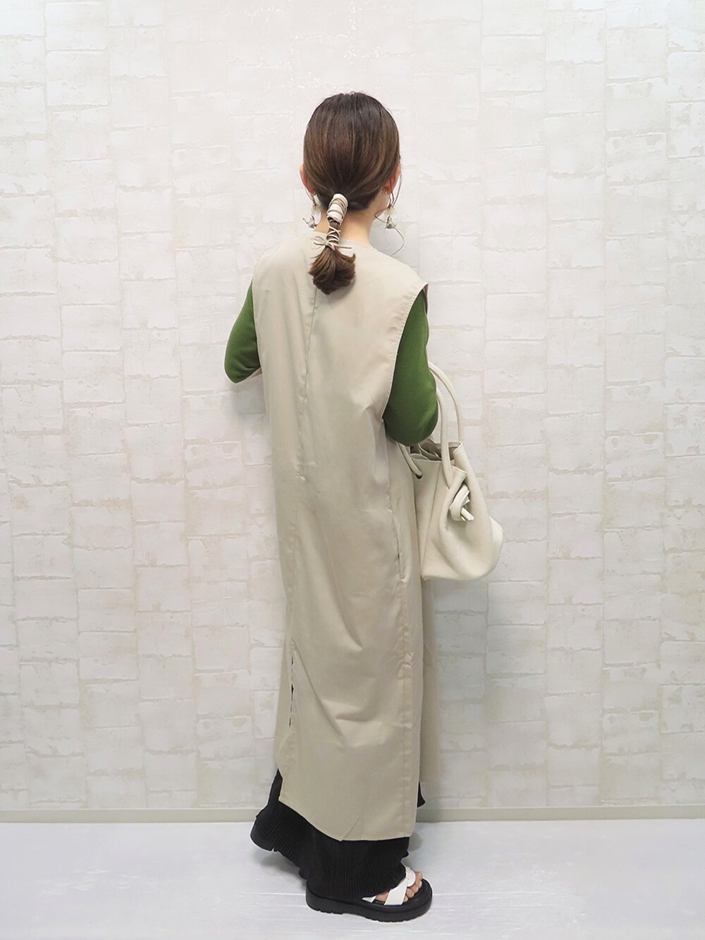 グリーン系のトップス、ブラック系のワンピース/ドレス、ベージュ系のベストを着用したレディースの夏コーディネートの2枚目の写真