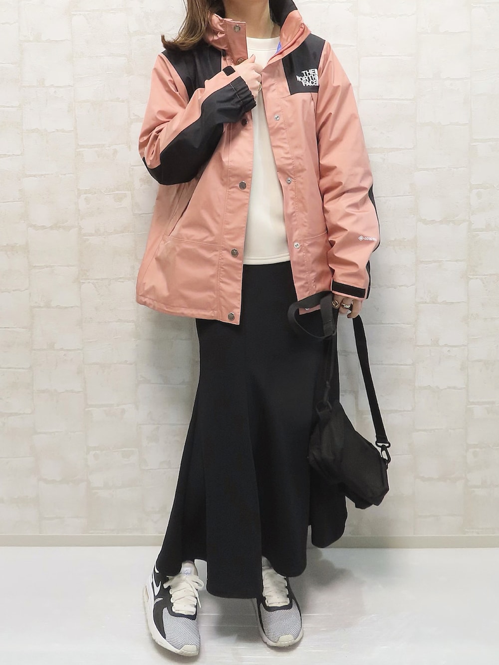 ピンク系のマウンテンパーカー、ホワイト系のTシャツ/カットソー、ホワイト系のスカートを着用したレディースの春コーディネートの4枚目の写真