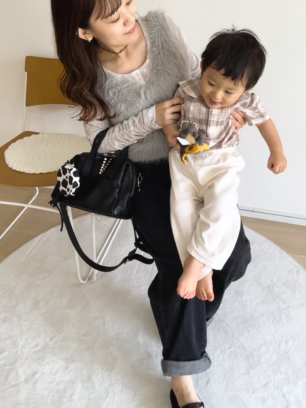 ホワイト系のTシャツ/カットソー、ブラック系のボストンバッグ、グレー系のベストを着用したレディースの秋コーディネートの2枚目の写真