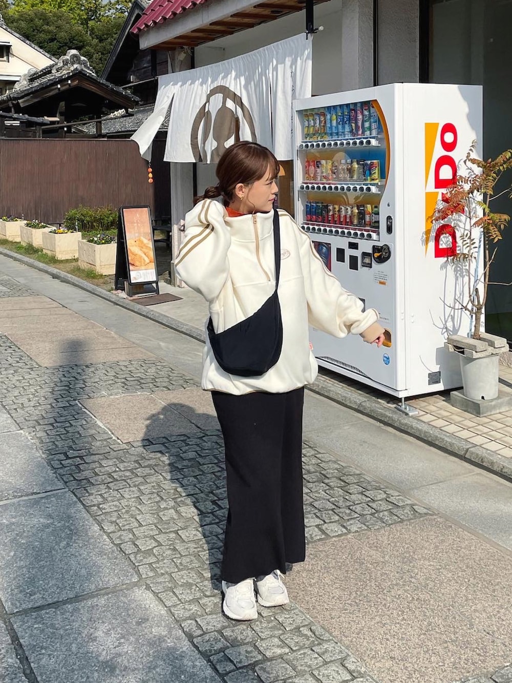 ホワイト系のスウェット、ブラウン系のニット/セーター、ブラック系のショルダーバッグを着用したレディースの秋コーディネートの3枚目の写真