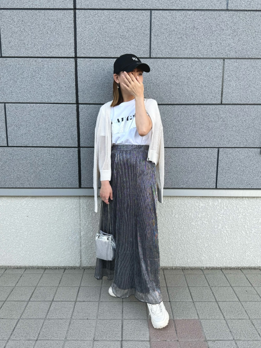 ホワイト系のTシャツ/カットソー、ブラック系のスカート、ホワイト系のカーディガン/ボレロを着用したレディースの夏コーディネートの4枚目の写真