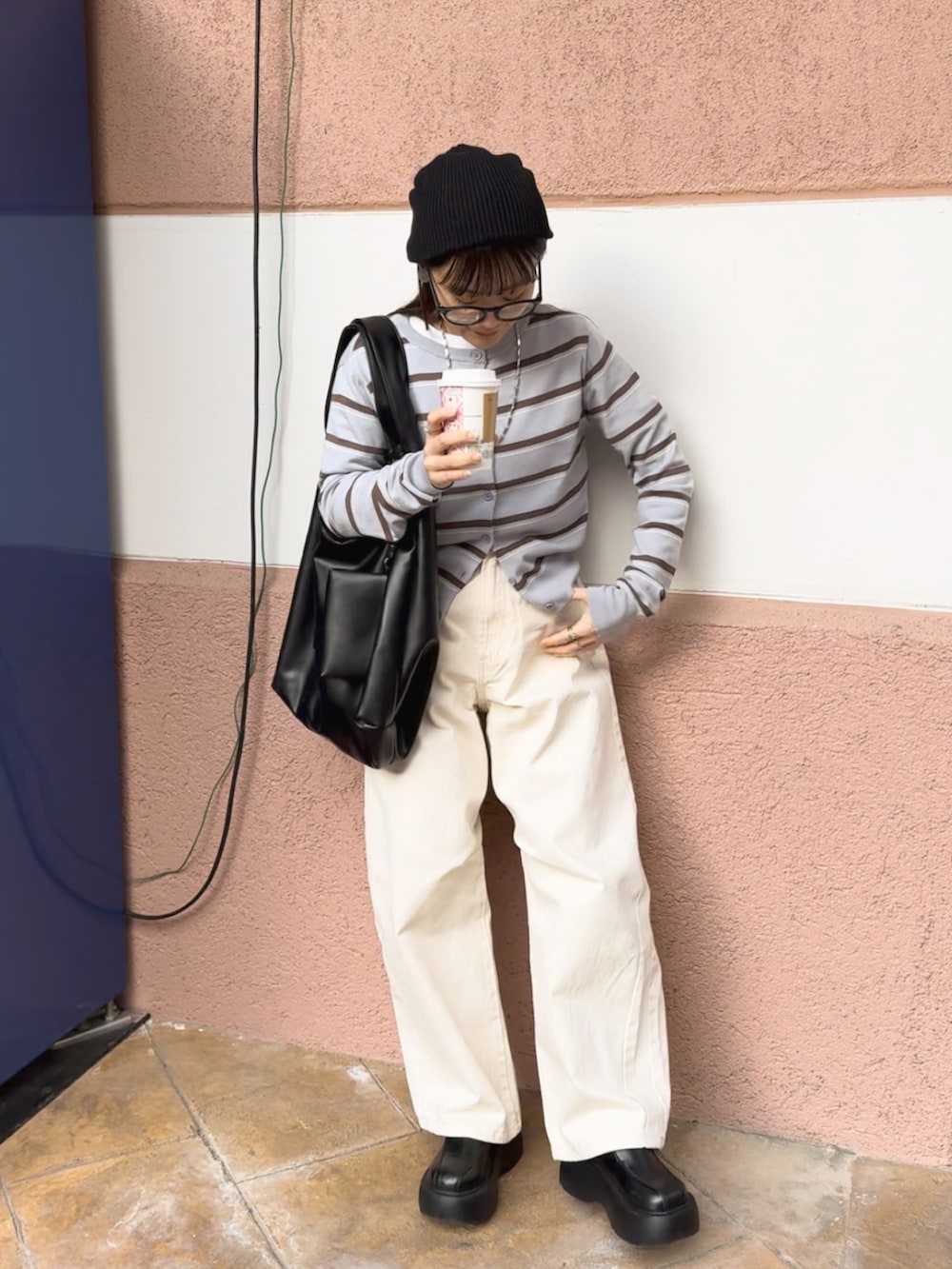 ブルー系のカーディガン/ボレロ、ホワイト系のパンツ、ブラック系のバッグを着用したレディースの春コーディネートの2枚目の写真