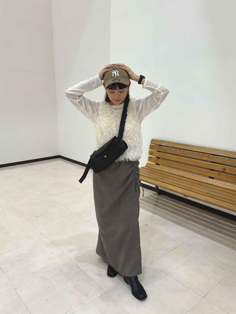 グレー系のスカート、ホワイト系のトップス、ホワイト系のTシャツ/カットソーを着用したレディースの秋コーディネートの2枚目の写真