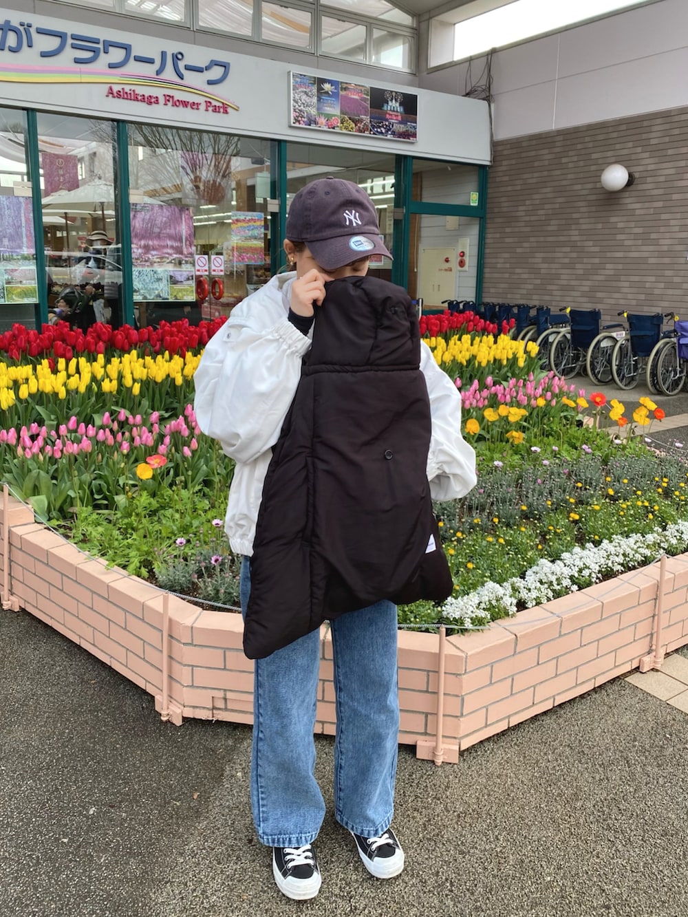 ホワイト系のマウンテンパーカー、ブルー系のデニムパンツ、グレー系のスウェットを着用したレディースの春コーディネートの4枚目の写真