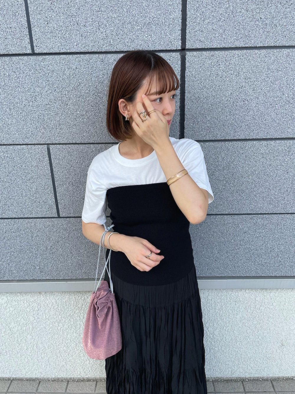 ブラック系のチューブトップ、ブラック系のスカート、ピンク系のショルダーバッグを着用したレディースの夏コーディネートの4枚目の写真