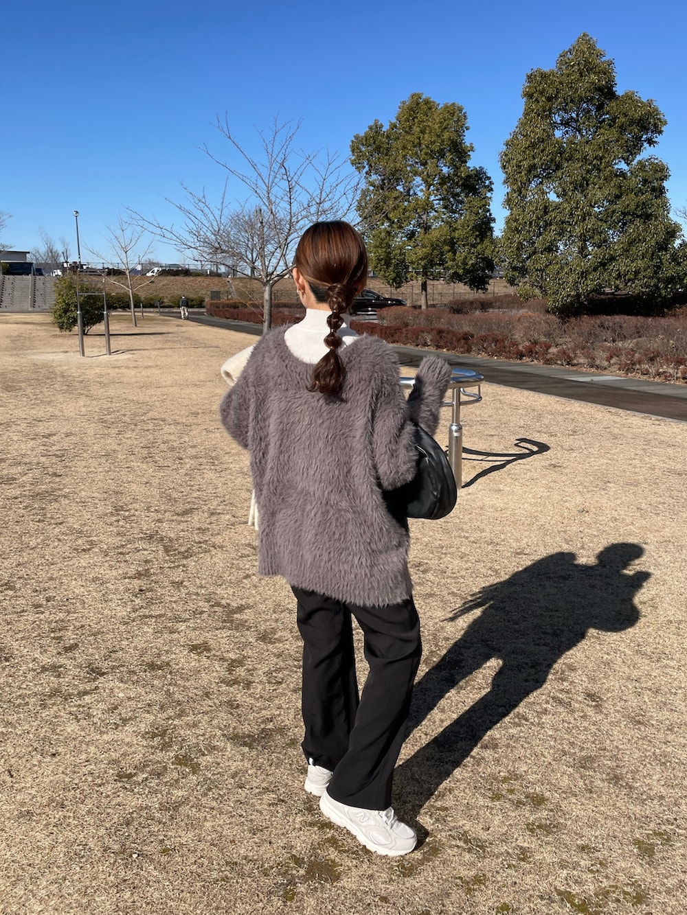 ベージュ系のカーディガン/ボレロ、ブラック系のスラックス、ホワイト系のスニーカーを着用したレディースの冬コーディネートの5枚目の写真