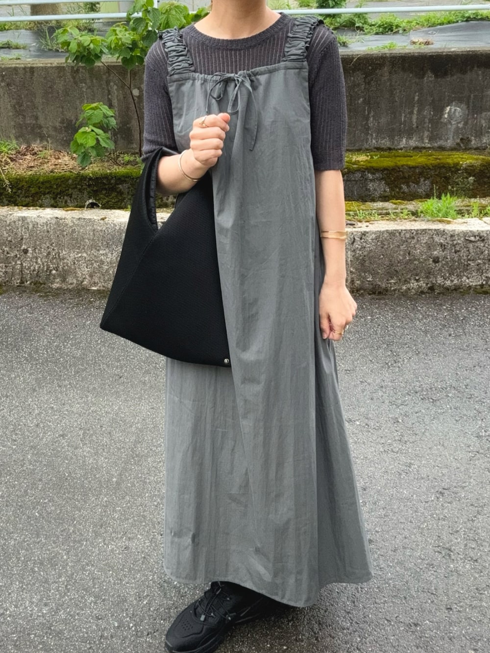 グレー系のワンピース、グレー系のトップス、ブラック系のトートバッグを着用したレディースの夏コーディネートの3枚目の写真