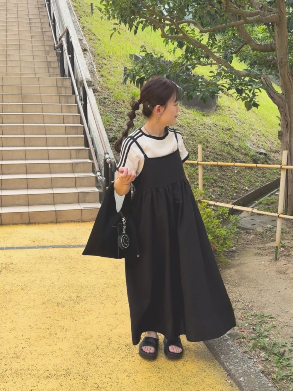 グレー系のセットアップ、ブラック系のワンピース、ブラック系のサンダルを着用したレディースの夏コーディネートの4枚目の写真