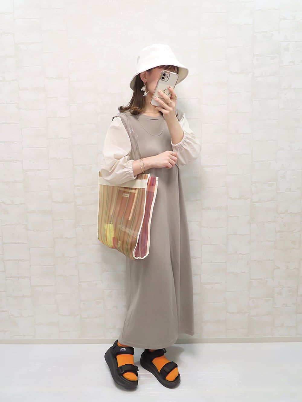 ベージュ系のワンピース、ホワイト系のトートバッグ、ホワイト系のハットを着用したレディースの春コーディネートの3枚目の写真