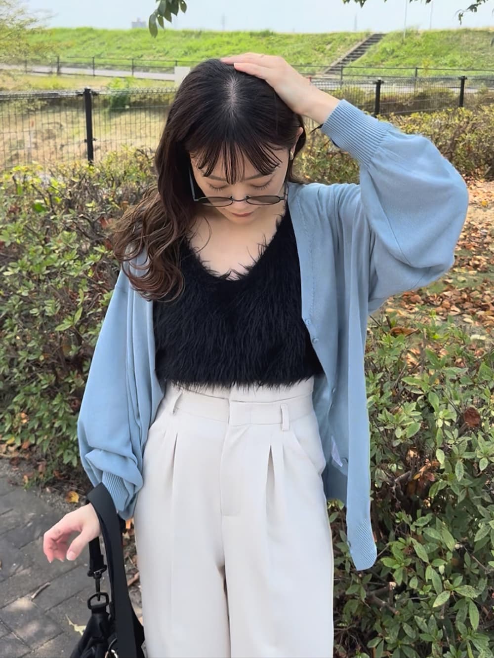 ブルー系のカーディガン/ボレロ、ホワイト系のスラックス、ブラック系のベストを着用したレディースの秋コーディネートの4枚目の写真