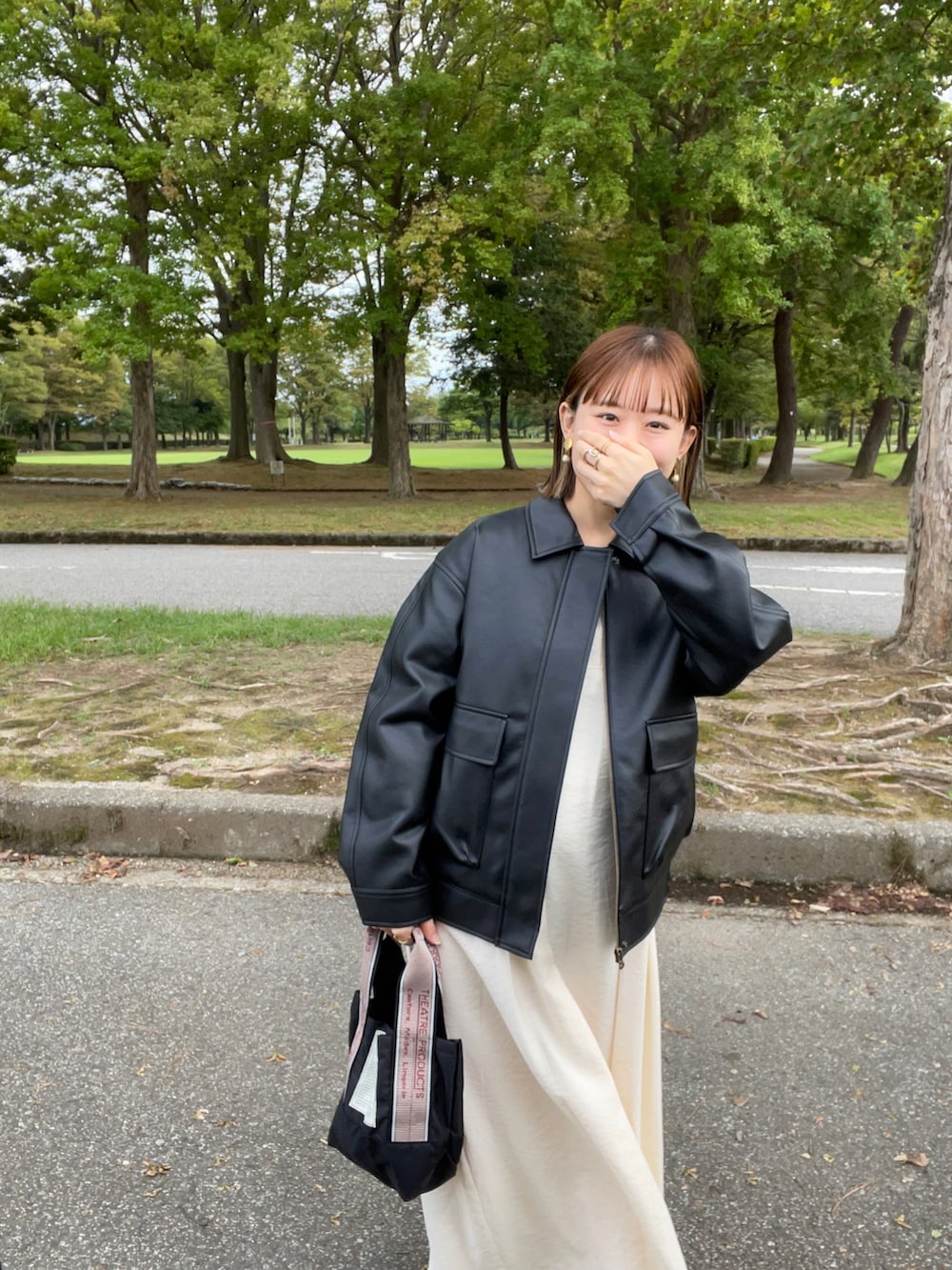 ブラック系のジャケット/アウター、ホワイト系のワンピース、ブラック系のショルダーバッグを着用したレディースの秋コーディネートの5枚目の写真