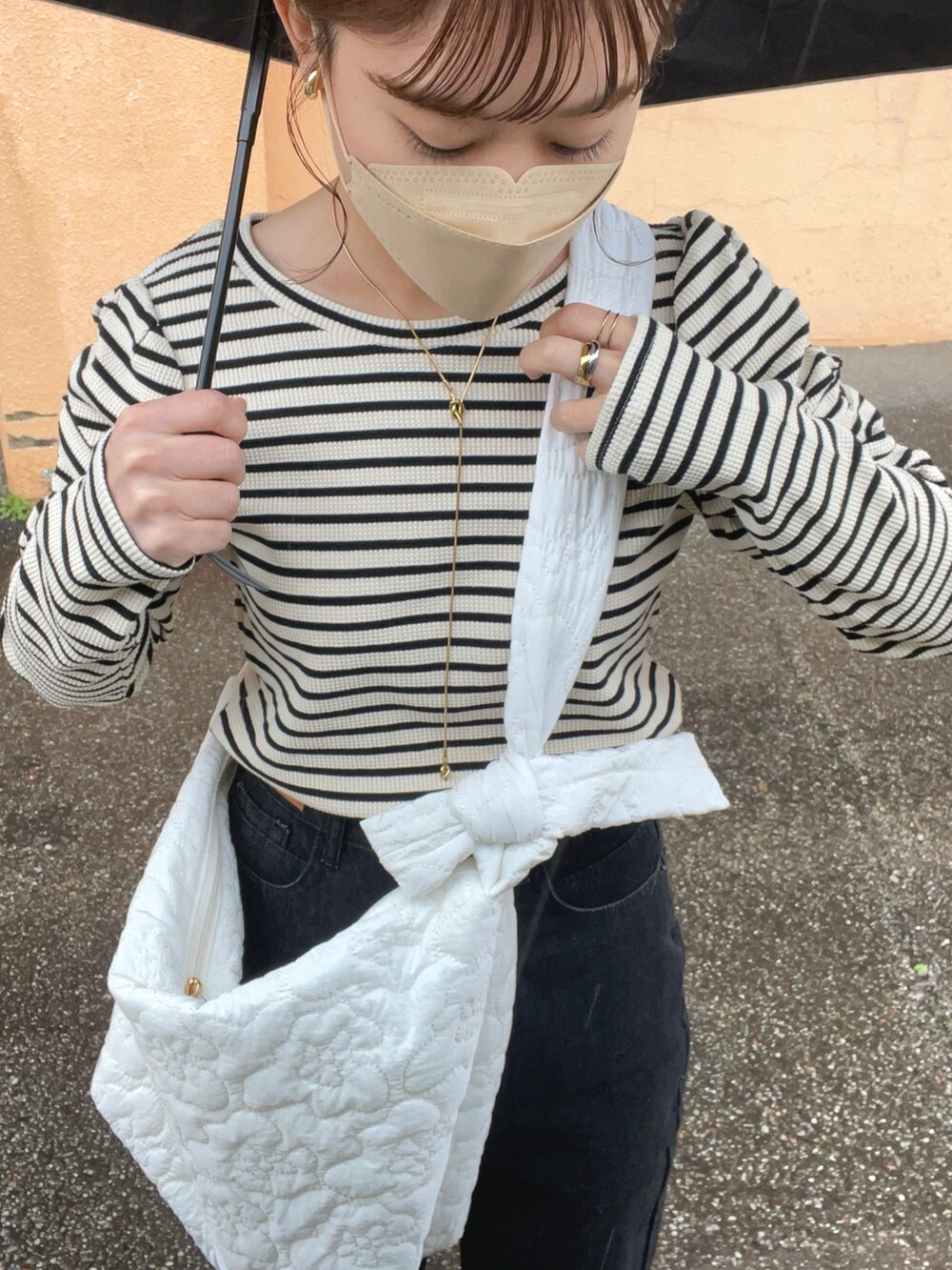 ブラック系のTシャツ/カットソー、ブラック系のデニムパンツ、ホワイト系のショルダーバッグを着用したレディースの春コーディネートの5枚目の写真