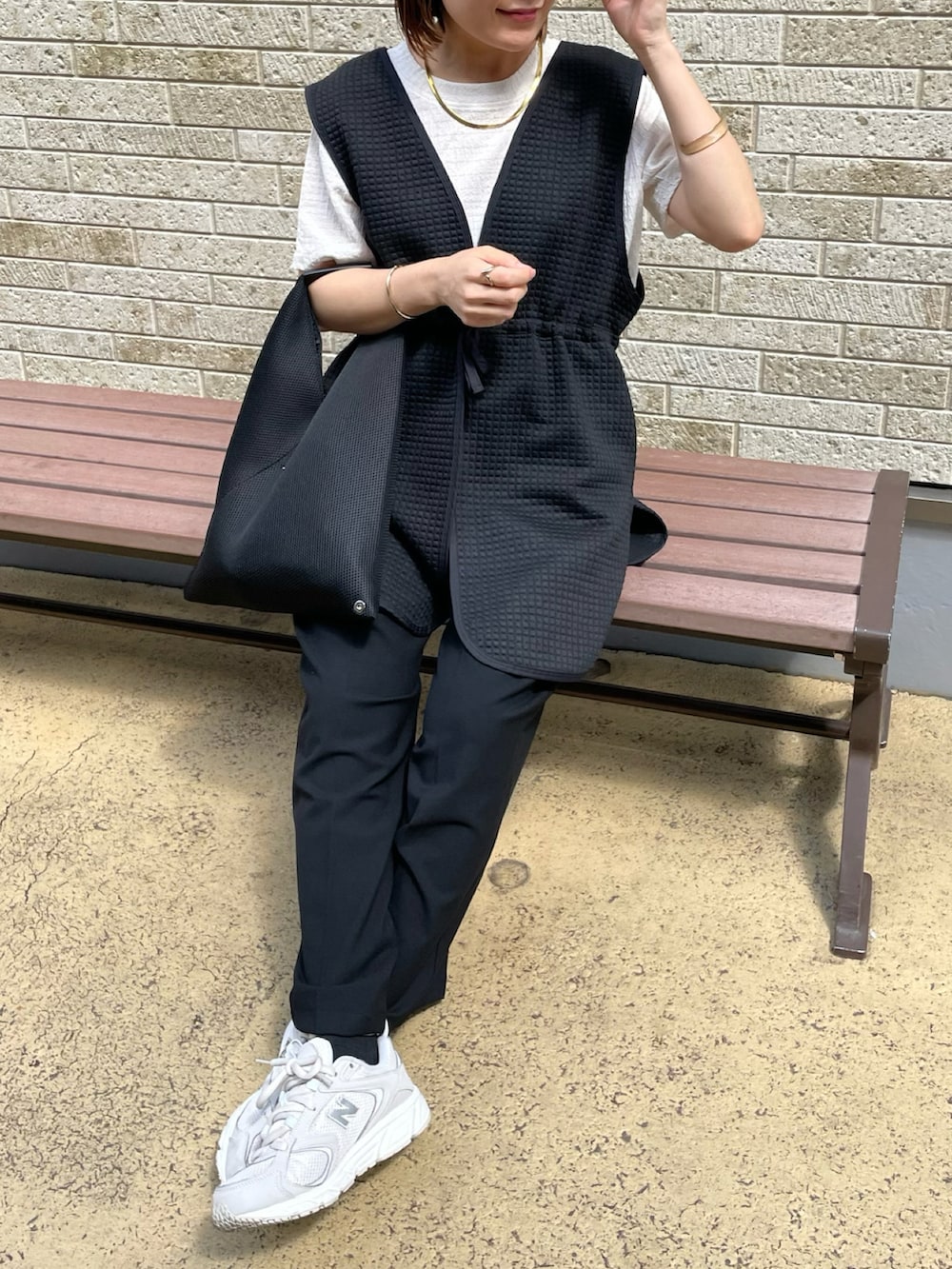 ブラック系のベスト、ホワイト系のTシャツ/カットソー、ブラック系のパンツを着用したレディースの夏コーディネートの3枚目の写真