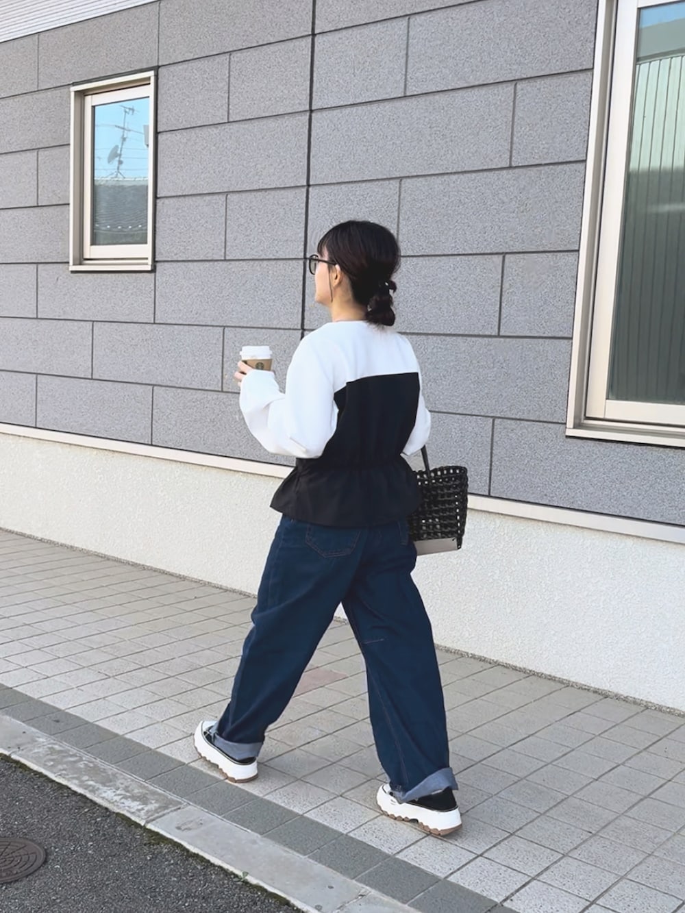 ホワイト系のTシャツ/カットソー、ブラック系のハンドバッグ、ブルー系のパンツを着用したレディースの春コーディネートの4枚目の写真