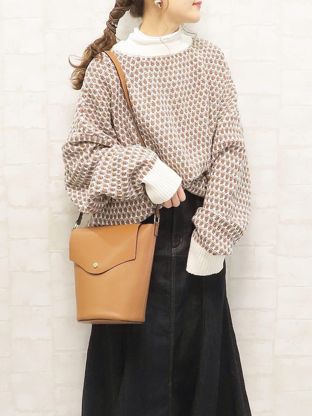 グレー系のニット/セーター、ブルー系のデニムスカート、ブラック系のブーツを着用したレディースの秋コーディネートの2枚目の写真