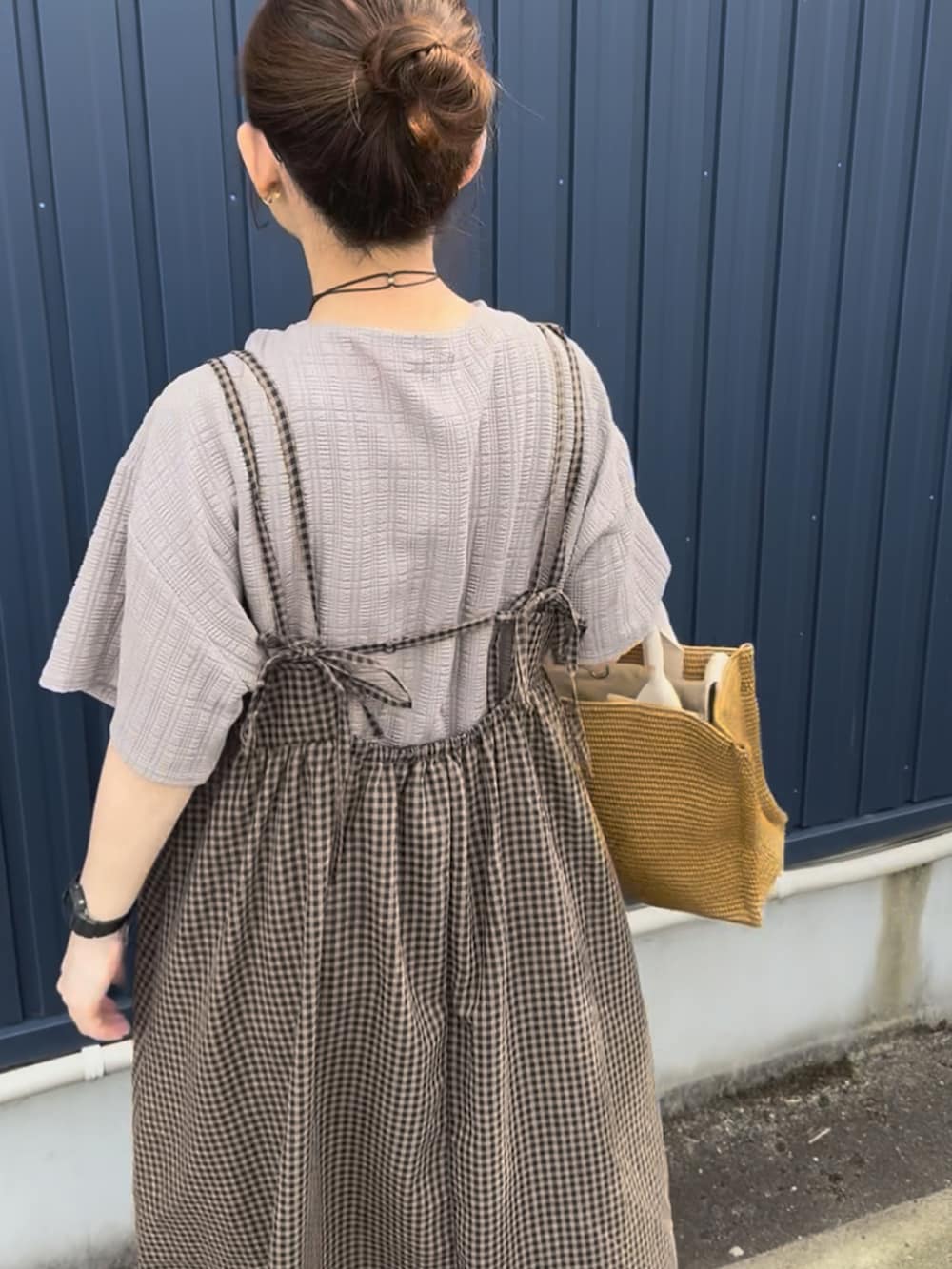ベージュ系のTシャツ/カットソー、ブラウン系のワンピース、ブラック系のサンダルを着用したレディースの夏コーディネートの2枚目の写真