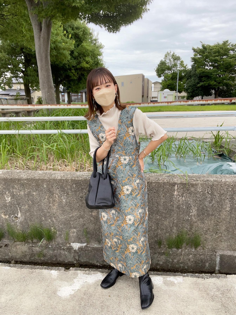 イエロー系のワンピース、ホワイト系のTシャツ/カットソー、ブラック系のハンドバッグを着用したレディースの秋コーディネートの5枚目の写真