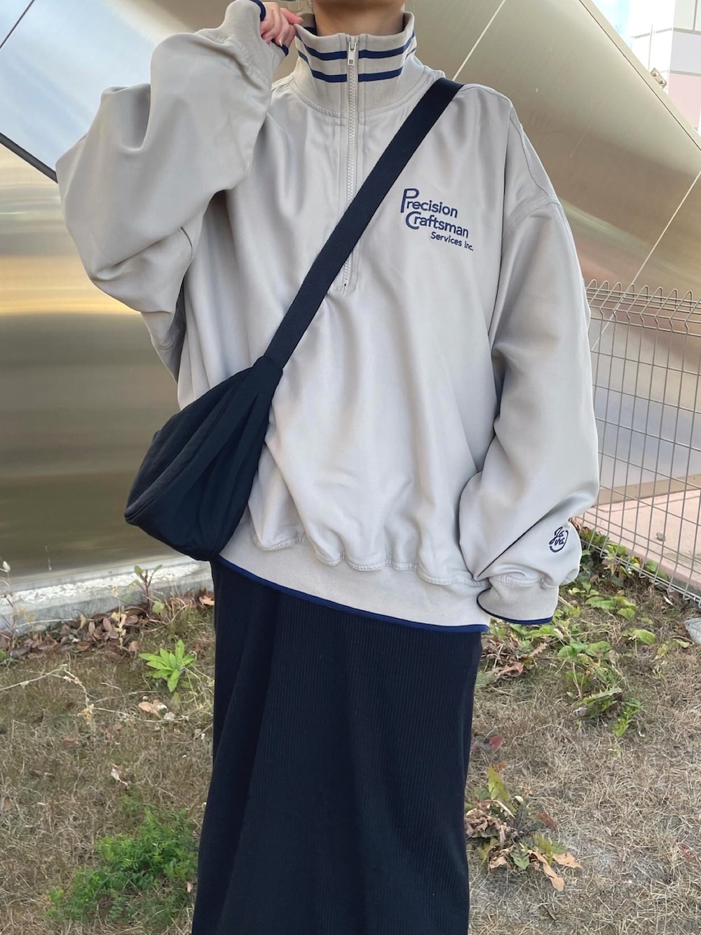 ベージュ系のスウェット、ブラック系のショルダーバッグ、ホワイト系のスニーカーを着用したレディースの冬コーディネートの4枚目の写真