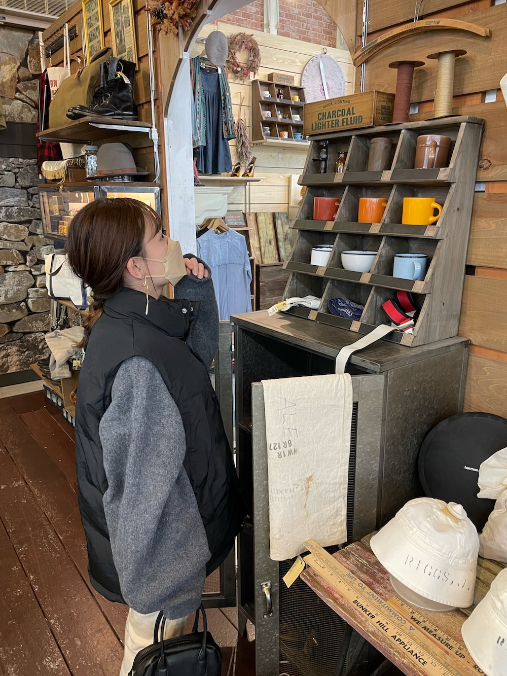 グレー系のニット/セーター、ブラック系のダウンベスト、ホワイト系のパンツを着用したレディースの冬コーディネートの3枚目の写真