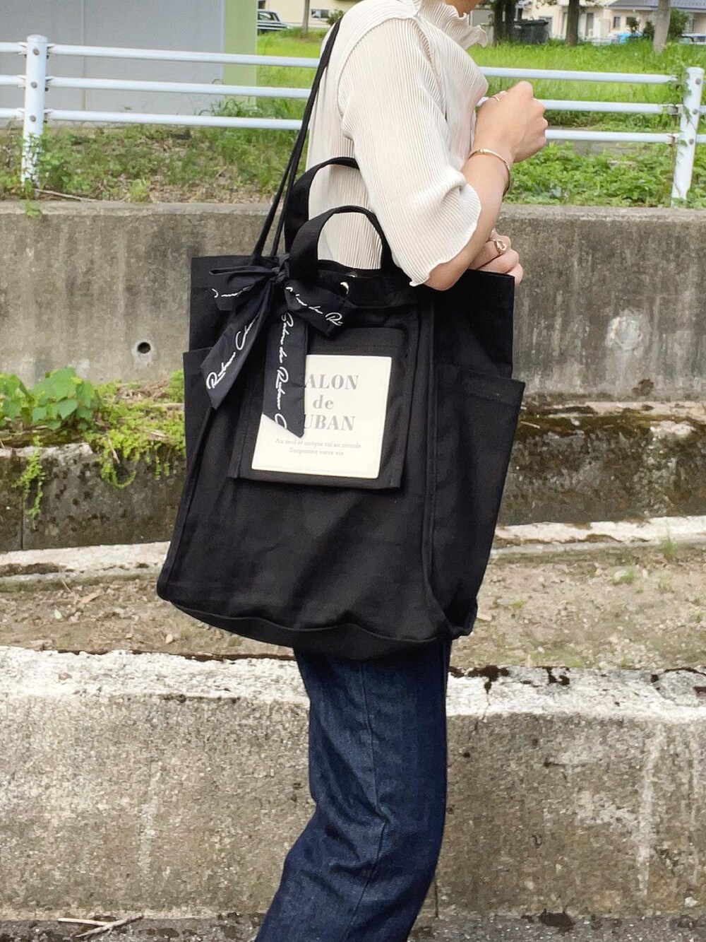 ホワイト系のTシャツ/カットソー、グレー系のベスト、ブラック系のトートバッグを着用したレディースの夏コーディネートの5枚目の写真