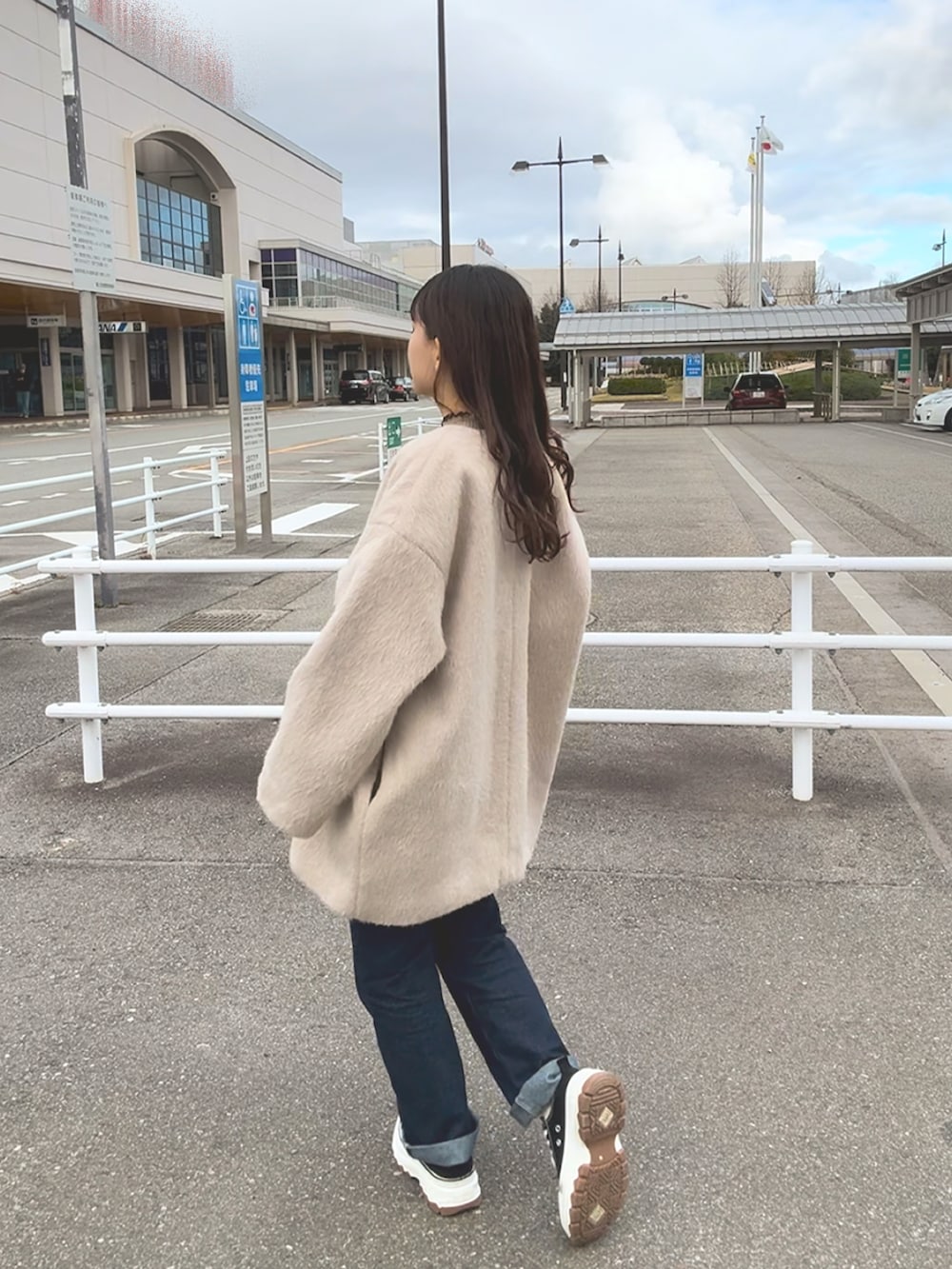 ブラウン系のニット/セーター、ベージュ系のジャケット/アウター、ブルー系のパンツを着用したレディースの冬コーディネートの4枚目の写真