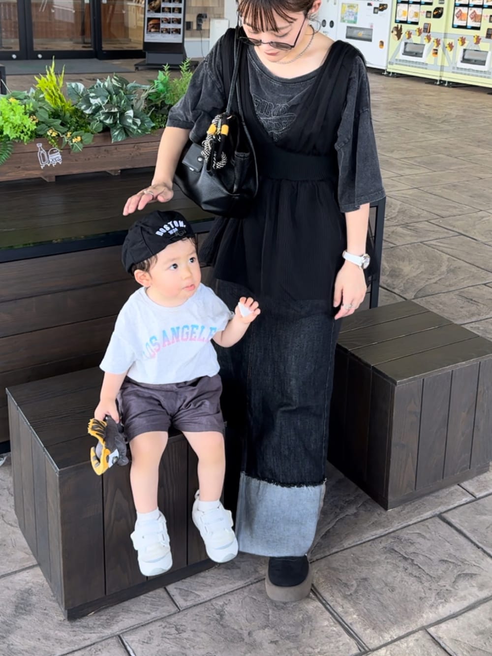 ブラック系のデニムスカート、グレー系のTシャツ/カットソー、ブラック系のベストを着用したレディースの秋コーディネートの4枚目の写真