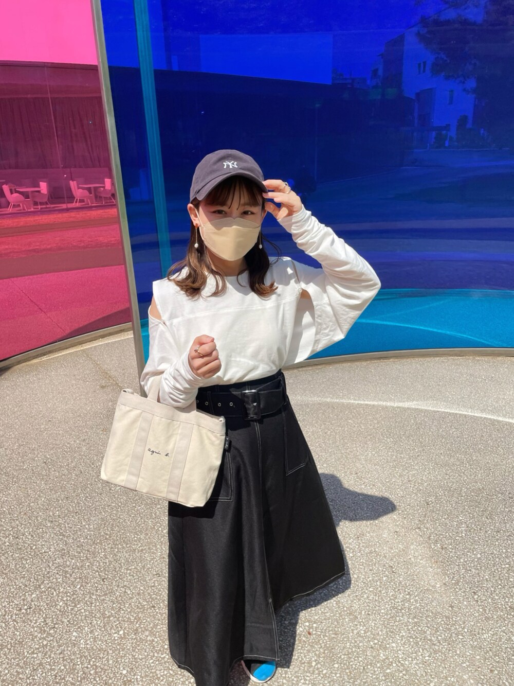 ホワイト系のトートバッグ、ホワイト系のトップス、ブラック系のスカートを着用したレディースの春コーディネートの4枚目の写真
