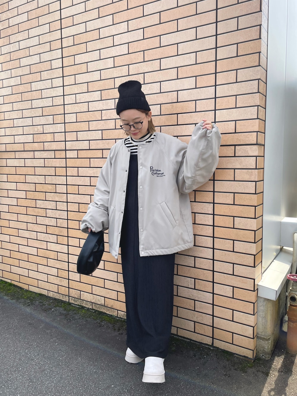 ベージュ系のブルゾン、ブラック系のワンピース/ドレス、ベージュ系のブーツを着用したレディースの冬コーディネートの4枚目の写真