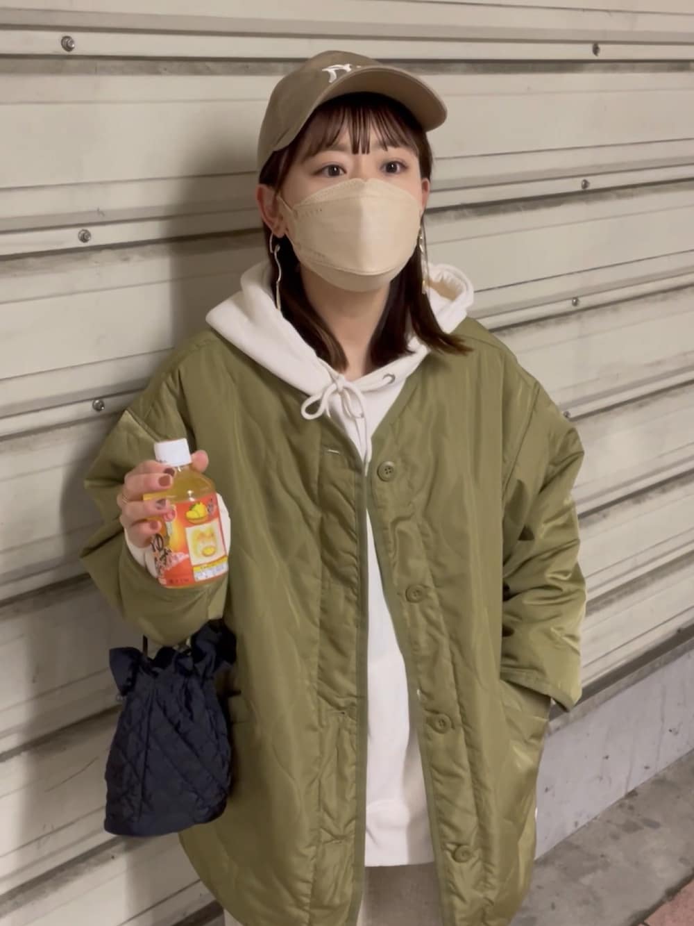 グリーン系のノーカラージャケット、ホワイト系のパーカー、ベージュ系のスカートを着用したレディースの冬コーディネートの5枚目の写真