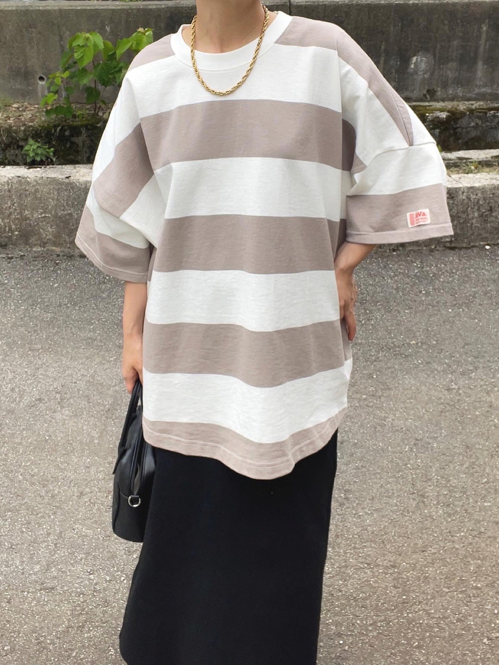 ベージュ系のTシャツ/カットソー、ブラック系のスカート、ホワイト系のハンドバッグを着用したレディースの夏コーディネートの4枚目の写真