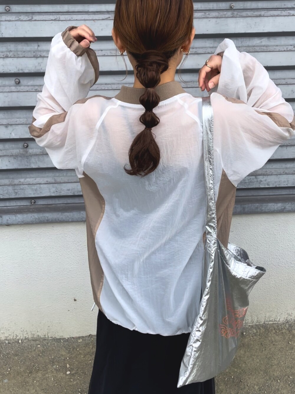 ホワイト系のTシャツ/カットソー、ブラック系のスカート、シルバー系のトートバッグを着用したレディースの春コーディネートの5枚目の写真