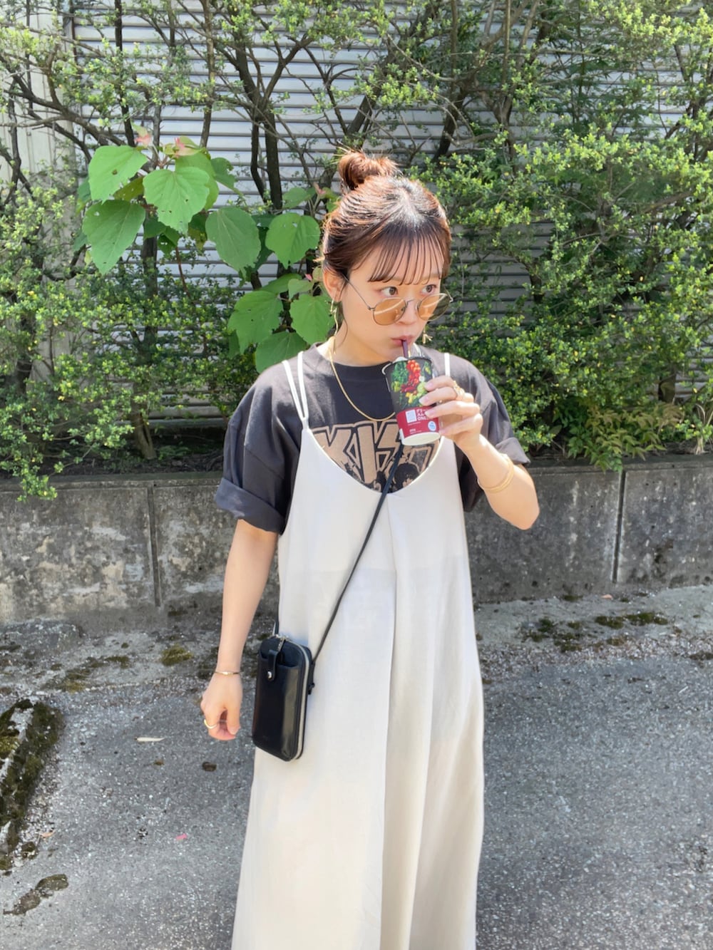 ベージュ系のワンピース、ブラック系のTシャツ/カットソー、ブラック系のショルダーバッグを着用したレディースの春コーディネートの2枚目の写真