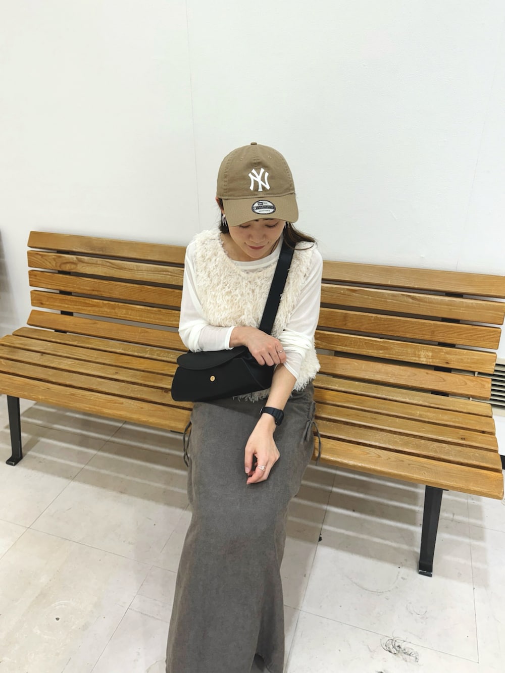 グレー系のスカート、ホワイト系のトップス、ホワイト系のTシャツ/カットソーを着用したレディースの秋コーディネートの4枚目の写真