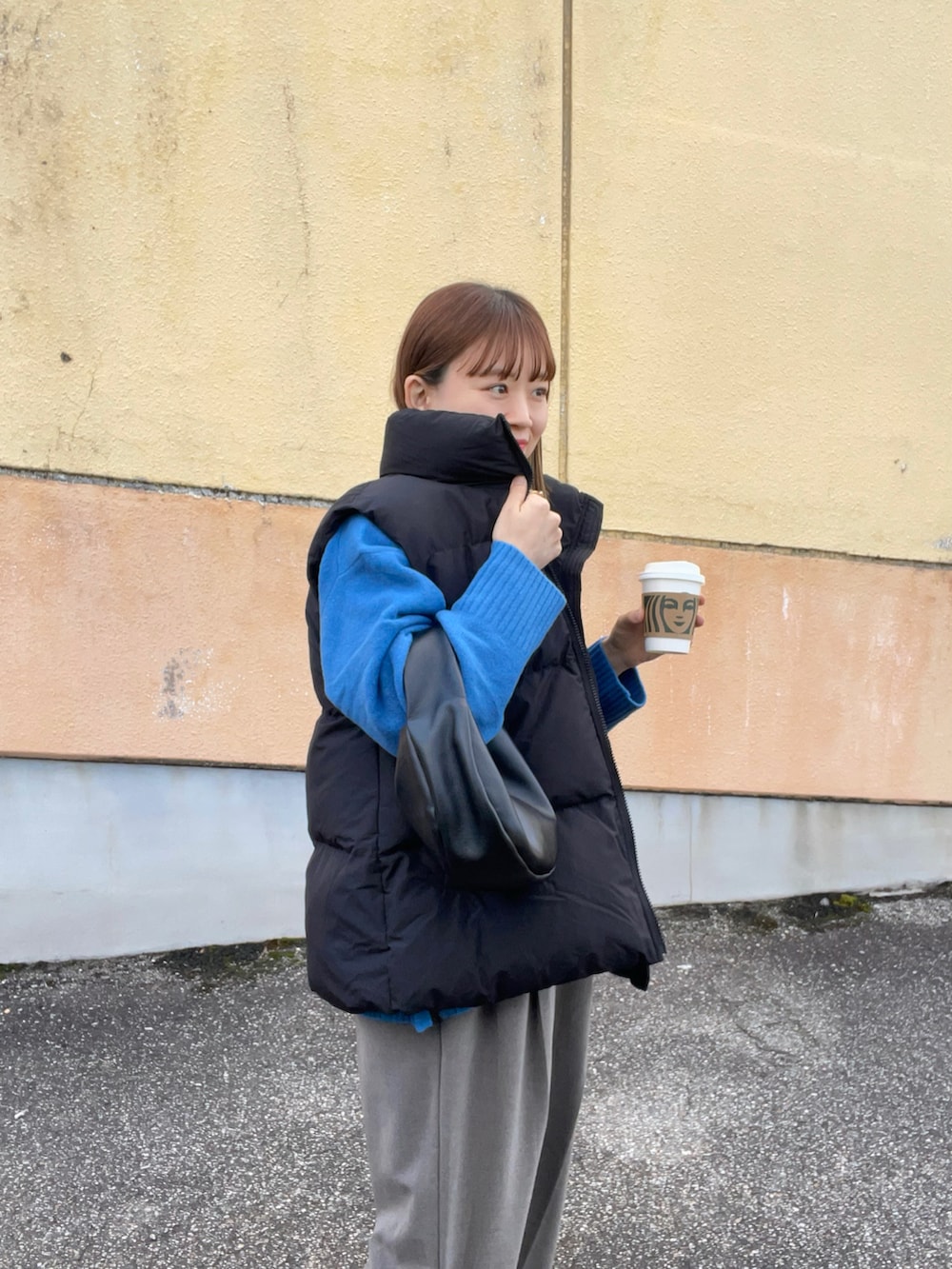 ブルー系のニット/セーター、ブラック系のベスト、ブラウン系のパンツを着用したレディースの秋コーディネートの4枚目の写真